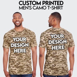 May include: A camouflage print t-shirt with the text "YOUR DESIGN HERE" printed on the front and back.
