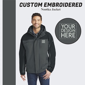 Pu&ograve; includere: Una giacca grigia e nera con cappuccio e chiusura a zip. La giacca ha un logo sul petto sinistro che dice "YOUR DESIGN HERE".