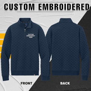 Peut inclure: Sweat-shirt bleu marine matelass&eacute; &agrave; fermeture &eacute;clair quart de zip avec le texte "CUSTOM EMBROIDERED" en haut. Le devant du sweat-shirt porte le texte "CUSTOM EMBROIDERY HERE". Le dos du sweat-shirt est &eacute;galement visible.