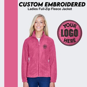 May include: A pink full-zip fleece jacket with a black embroidered logo that says "YOUR LOGO HERE".