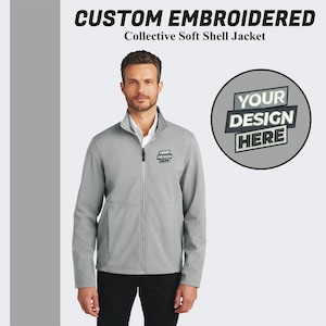 May include: A gray soft shell jacket with a zipper closure. The jacket has a stand-up collar and two front pockets. The jacket is embroidered with the text "YOUR DESIGN HERE".