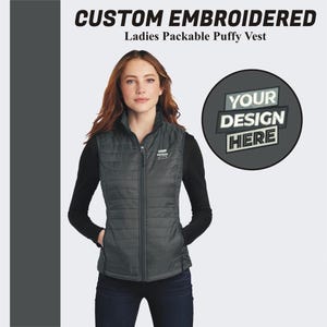 May include: A black packable puffer vest with a zipper closure. The vest has a quilted design and two pockets. The vest is shown on a model. The text "YOUR DESIGN HERE" is shown in a circle.