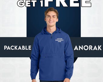 May include: A blue packable anorak jacket with a hood and a front pocket. The jacket has the text "CUSTOM EMBROIDERY HERE" embroidered on the chest. The image also includes the text "BUY 1 GET 1 FREE".