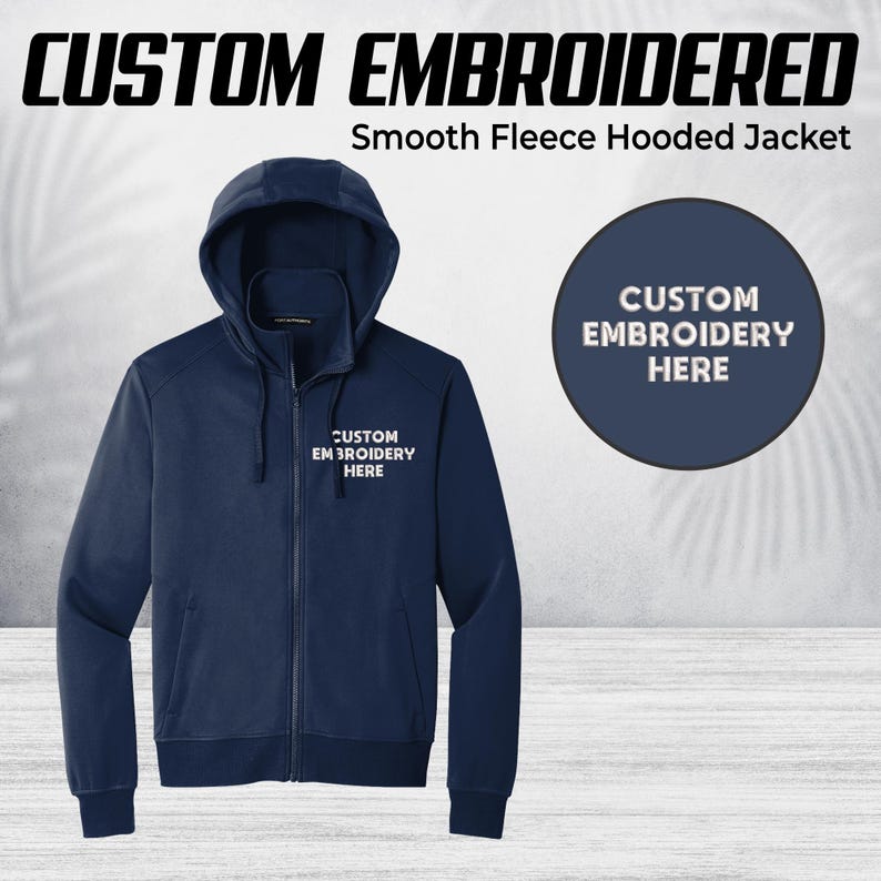 Pode incluir: Casaco com capuz de l&atilde; lisa azul marinho com z&iacute;per completo e capuz. O casaco tem o texto "CUSTOM EMBROIDERED" e "CUSTOM EMBROIDERY HERE". Um c&iacute;rculo azul marinho tamb&eacute;m mostra "CUSTOM EMBROIDERY HERE".