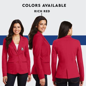 Puede incluir: Una chaqueta roja con dos botones y un bolsillo en el lado izquierdo. La chaqueta se muestra en una modelo desde el frente, el lado y la espalda.