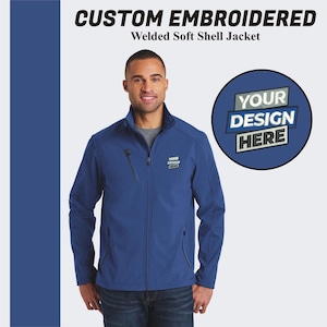 May include: A blue soft shell jacket with a zipper closure and two pockets. The jacket has a mock neck and is embroidered with the text "YOUR DESIGN HERE".