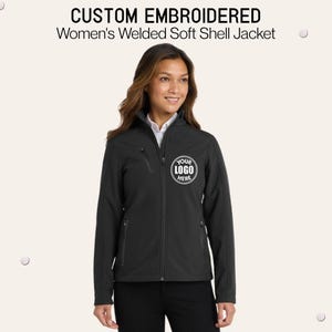 May include: A black soft shell jacket with a full-length front zipper, a high collar, and zippered pockets. The chest features a circular graphic with the text 'YOUR LOGO HERE'. The text 'CUSTOM EMBROIDERED Welded Soft Shell Jacket' appears above.