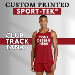May include: A red and white Club Track Tank top and shorts. The tank top has white accents on the shoulders and sides, with the text "YOUR DESIGN HERE" in white. The image also includes the text "CUSTOM PRINTED SPORT-TEK".