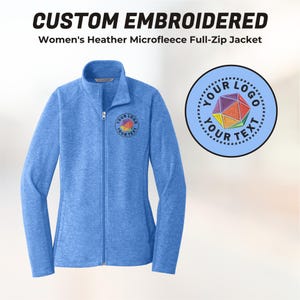 May include: A light blue, full-zip microfleece jacket with a custom embroidered logo. The jacket has a stand-up collar and a zipper closure. The logo is a colorful geometric design inside a circle with the text "YOUR LOGO YOUR TEXT".