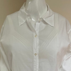 May include: A white long-sleeved button-down shirt with a classic collar.
