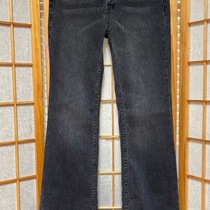 May include: Black flared jeans with a button fly and the Free People logo on the back pocket.