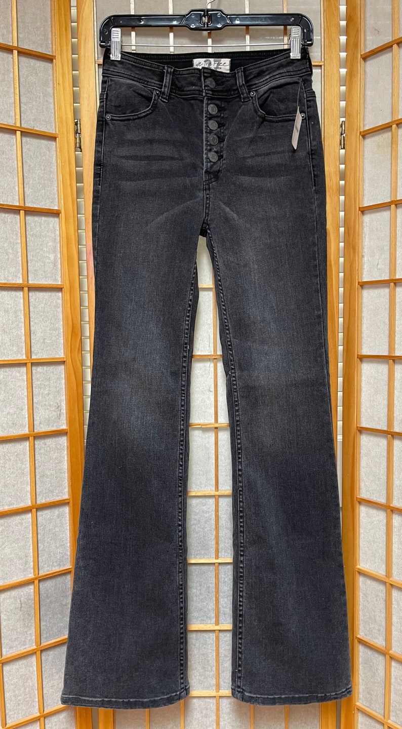 May include: Black flared jeans with a button fly and the Free People logo on the back pocket.