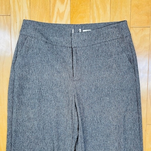 May include: A pair of dark gray, straight-leg pants with a zipper fly and button closure.