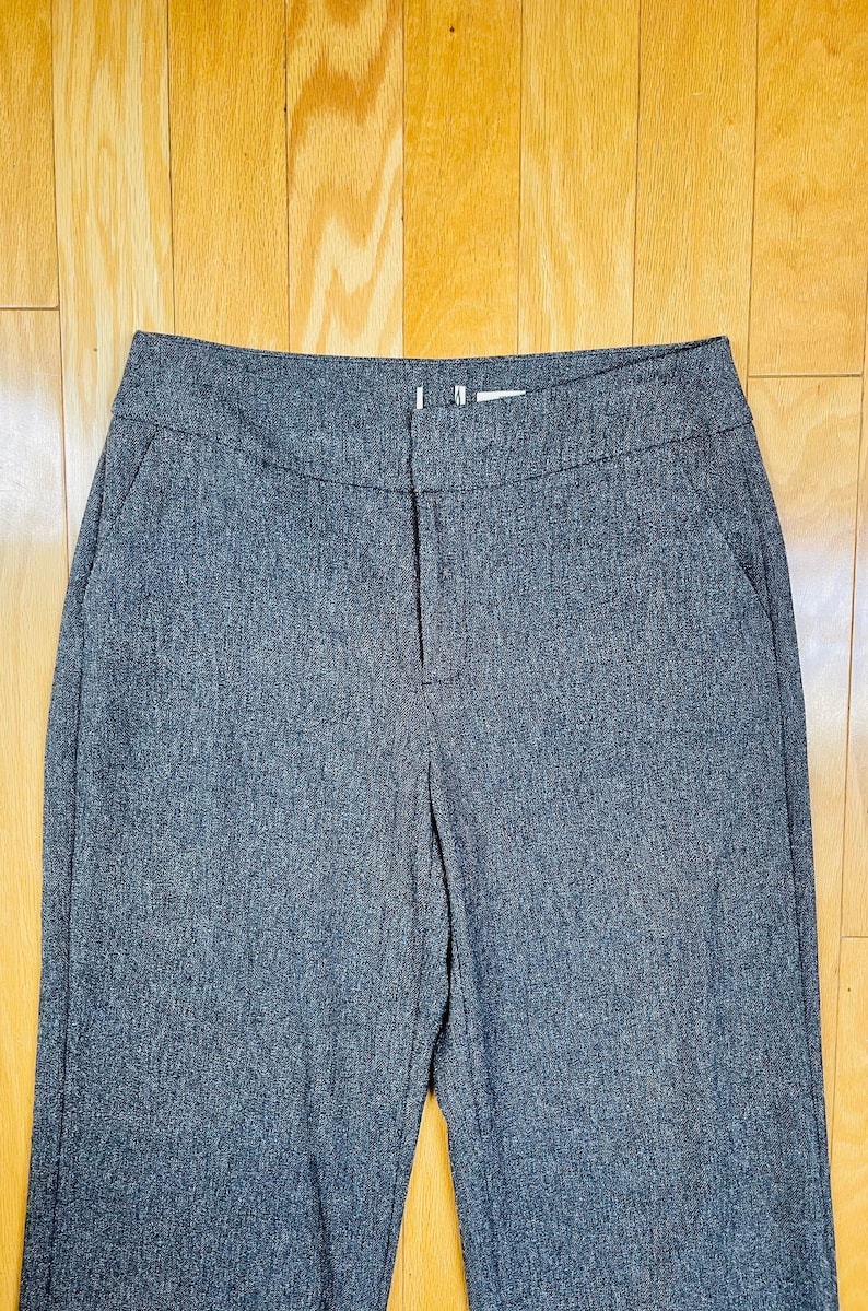 May include: A pair of dark gray, straight-leg pants with a zipper fly and button closure.