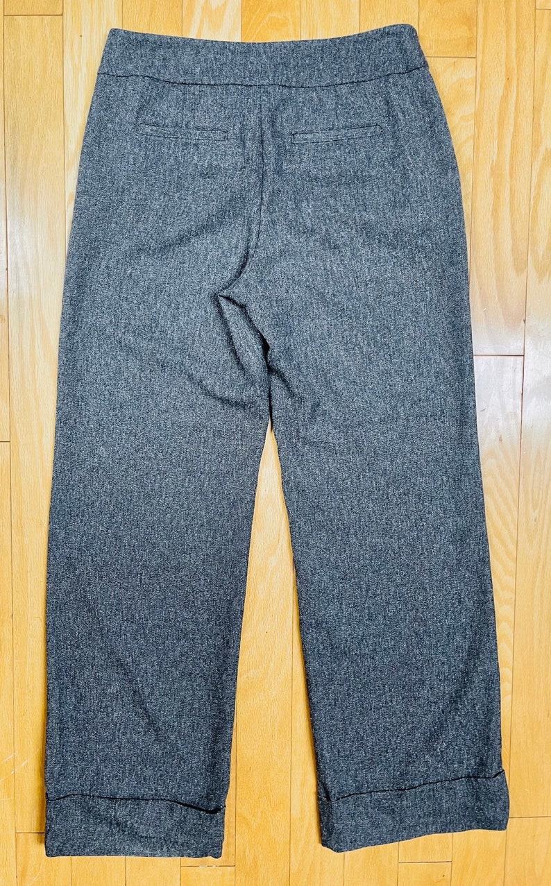 May include: Gray cuffed pants with a textured woven fabric.