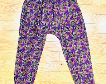 May include: Purple, orange, and green floral print pants with a wide elastic waistband and a matching tie belt.