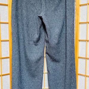 May include: Gray wide-leg pants with a cuffed hem. The pants have a subtle textured pattern and a dark gray waistband.