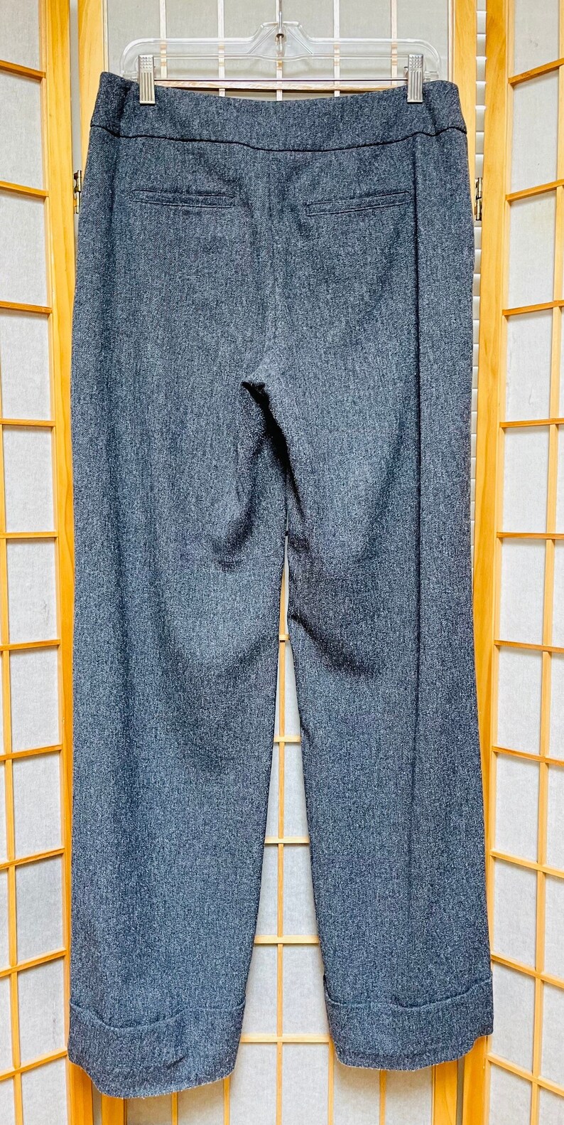 May include: Gray wide-leg pants with a cuffed hem. The pants have a subtle textured pattern and a dark gray waistband.