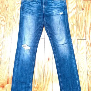 K&ouml;nnte beinhalten: Blaue Jeans aus Denim mit Destroyed-Effekt und gerader Passform. Die Jeans haben eine helle Waschung und ein paar kleine Risse.