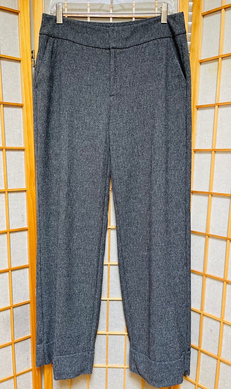 May include: Gray wide-leg pants with a cuffed hem. The pants have a straight leg and a mid-rise waist.