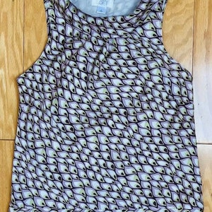 May include: A sleeveless, purple and white patterned top with a cowl neck. The top has a black and white pattern of teardrop shapes. The brand name "LOFT" is visible on the tag.