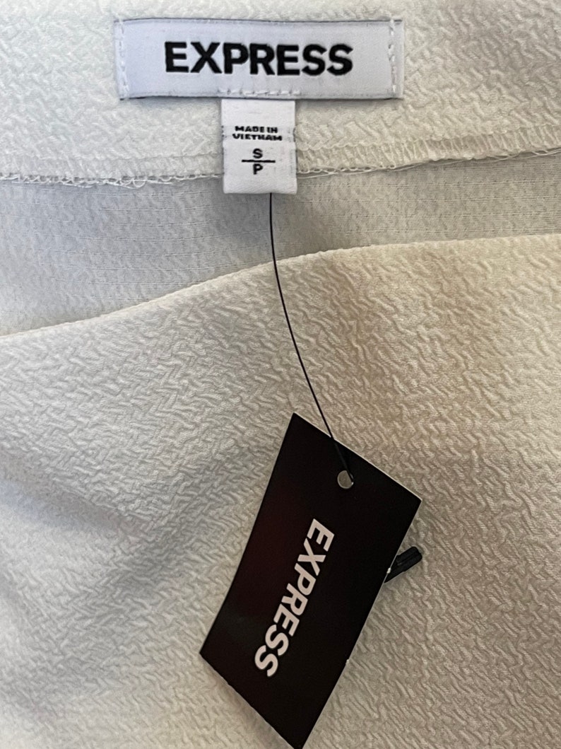 May include: White clothing tag with black text that reads "EXPRESS" and "MADE IN VIETNAM". The tag also has a size label that reads "S" and "P".