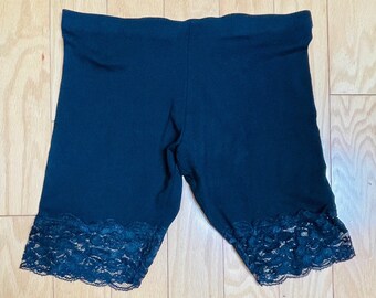 May include: Black shorts with a lace trim. The shorts are made of a stretchy fabric and have a comfortable fit.