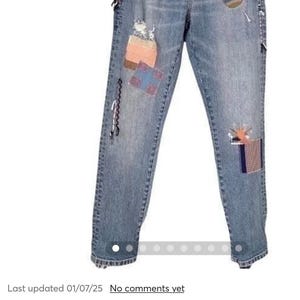K&ouml;nnte beinhalten: Distressed Blue Wash Jeans mit gestickten Patches. Die Jeans haben eine lockere Passform und ein gerades Bein. Die Patches sind bunt und haben geometrische Muster.