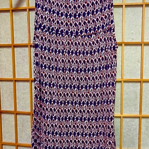May include: A sleeveless white tank top with a geometric pattern in shades of red, blue, and white.
