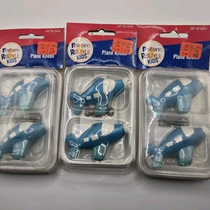 May include: A white ceramic mug with a black handle and the text "But First, Coffee" in a black, bold font. The mug is on a white surface.