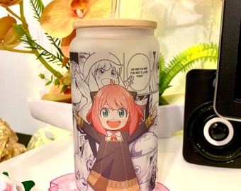 Pode incluir: Um copo de vidro reutilizável branco com um design de personagem de anime rosa e branco. O copo tem uma tampa de bambu e um canudo de plástico transparente. O copo está sentado em um descanso de copo rosa em forma de flor.