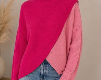 Könnte beinhalten: Ein langärmeliger Pullover mit Stehkragen und zweifarbigem Design. Das Kleidungsstück ist diagonal geteilt, mit einem leuchtenden Fuchsia-Pink auf der einen Seite und einem helleren, zarten Pastellrosa auf der anderen, mit gerippten Bündchen.