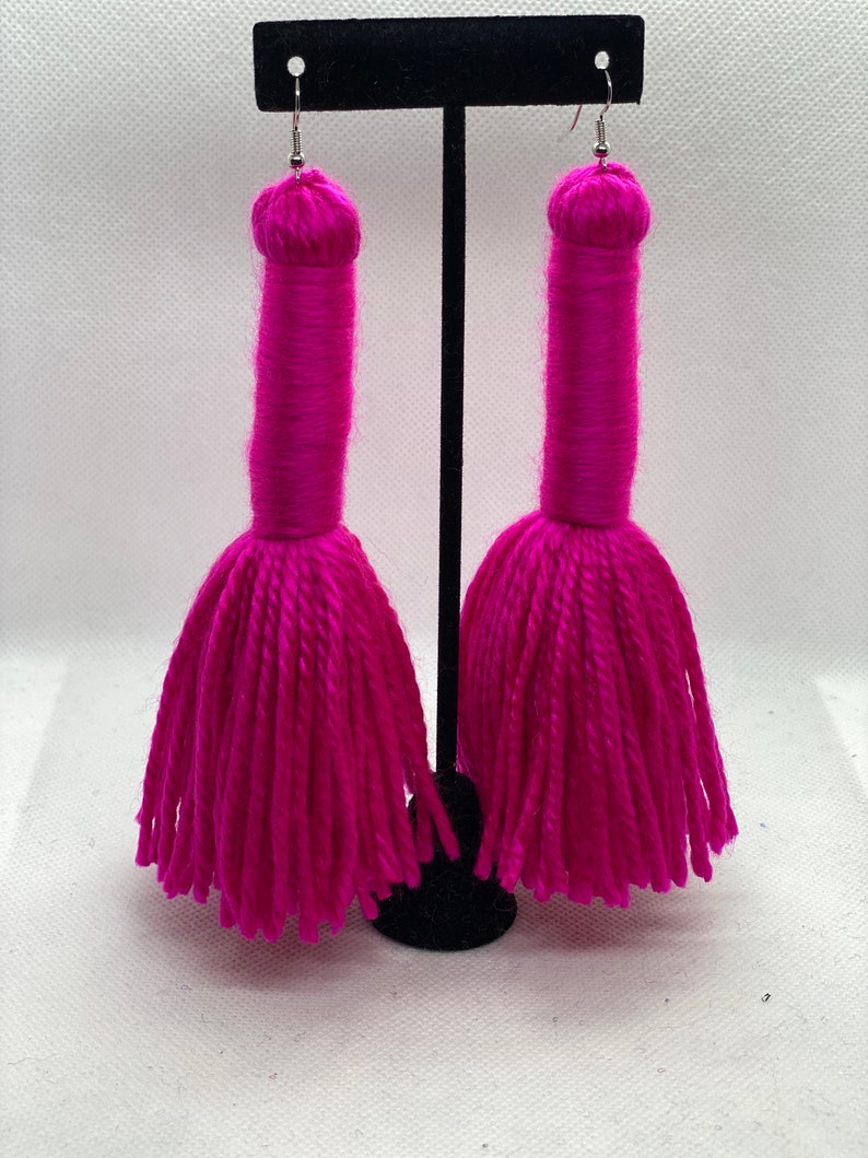 May include: A pair of long, pink tassel earrings. The tassels are made of yarn and are about 3 inches long.