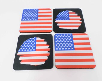 May include: Set of four square American flag coasters. Two coasters feature a full-color American flag, while the other two coasters feature a distressed American flag design.