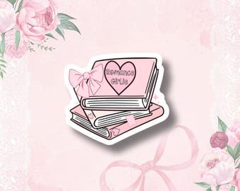 May include: A pink sticker featuring a stack of books with the text "Romance Girlie" inside a heart. A pink bow is attached to the top book. The sticker has a white border and is set against a pink floral background.
