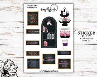 May include: A sticker sheet with a chalkboard Halloween theme. The sheet includes stickers with phrases like "Trick or Treat", "Important", "Checklist", "To Do", "Spooky Vibes", "Cozy Halloween", "Today", and "Happy Halloween Boo's". There are also stickers of a bookshelf with books, a candle, a coffee cup, and a tiered tray with cats and a ghost.