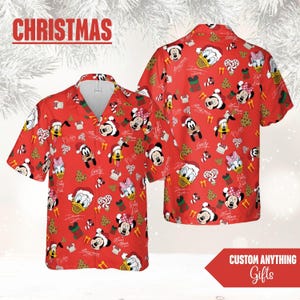 May include: Red Christmas-themed button-down shirt featuring Disney characters like Mickey Mouse, Minnie Mouse, Donald Duck, and Pluto, along with Christmas elements. The shirt has a festive pattern with the word "Christmas" at the top.