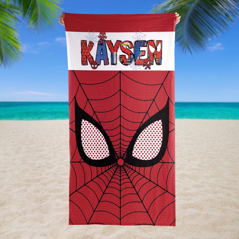 May include: Red beach towel featuring a Spider-Man design. The towel has a red spiderweb pattern with large black eyes and a white dotted pattern. The name "Kaysen" is printed in colorful letters across the top.