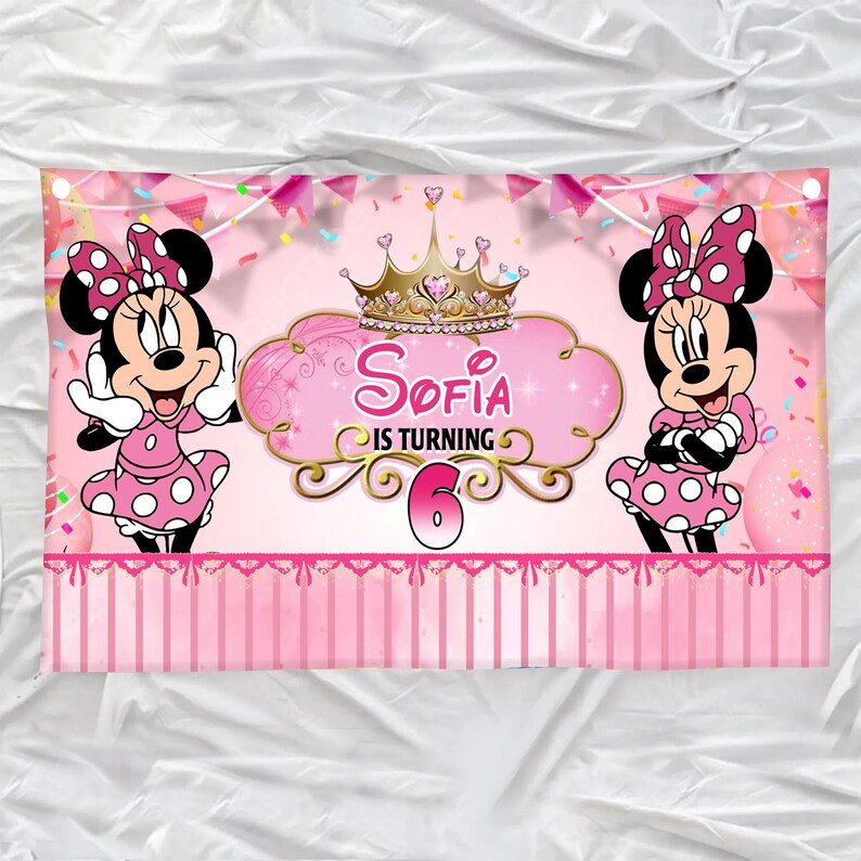 Op de afbeelding: Roze verjaardagsbanner met Minnie Mouse-personages. De banner heeft de tekst "Sofia wordt 6" in een goud en roze ontwerp, met een gouden kroon. Minnie Mouse staat aan weerszijden van de tekst en draagt een roze polkadotjurk.