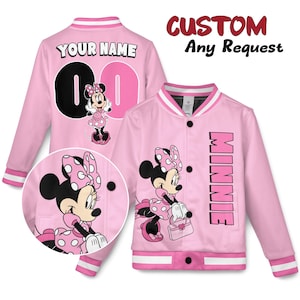 May include: Pink varsity jacket featuring Minnie Mouse. The jacket has a white collar and cuffs with pink and white stripes. The front of the jacket has a Minnie Mouse graphic and the word "MINNIE". The back has the text "YOUR NAME" and the number "0".