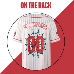 Puede incluir: Camiseta de b&eacute;isbol blanca con finas rayas rojas, con el texto "YOUR NAME" sobre el n&uacute;mero rojo "00" con un dise&ntilde;o de telara&ntilde;a. La camiseta tiene un logo de Spider-Man en la manga y el texto "ON THE BACK" en la parte superior.
