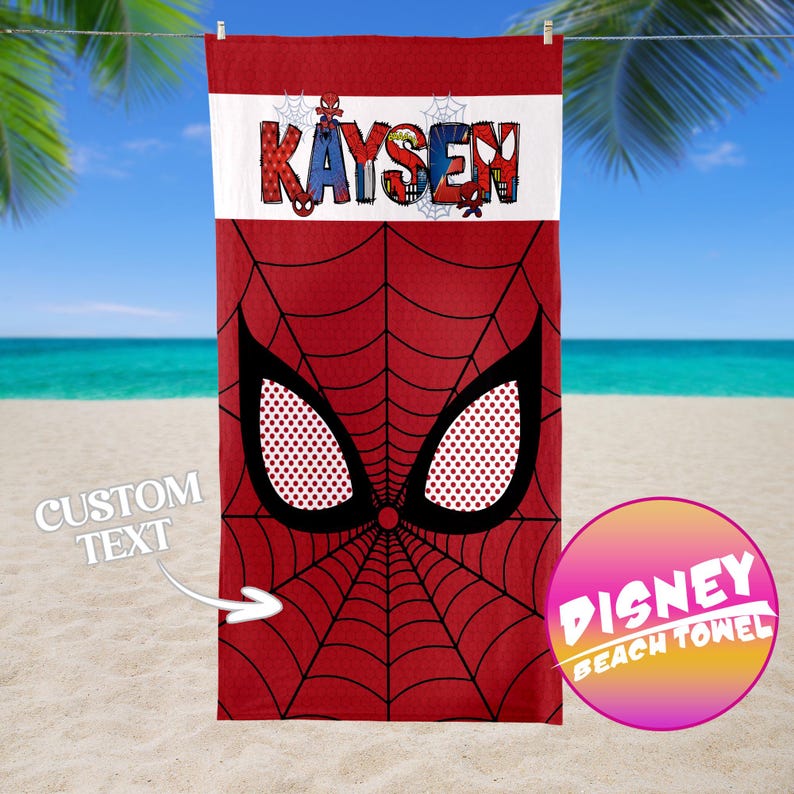 May include: Red beach towel featuring a Spider-Man design with a web pattern and large eye details. The towel has a white band with the name "Kaysen" in colorful letters. A Disney Beach Towel logo is visible.