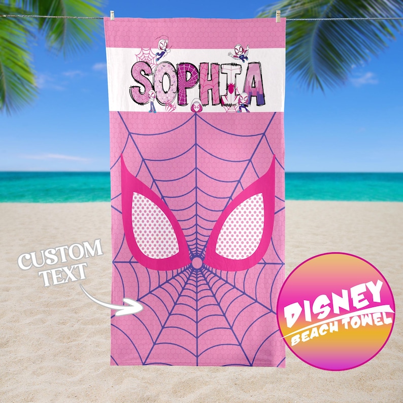 May include: Pink beach towel featuring a Spider-Man web design and the name "SOPHIA" in purple letters. The towel has a pink and white color scheme with a "DISNEY BEACH TOWEL" logo. The words "CUSTOM TEXT" are also visible.