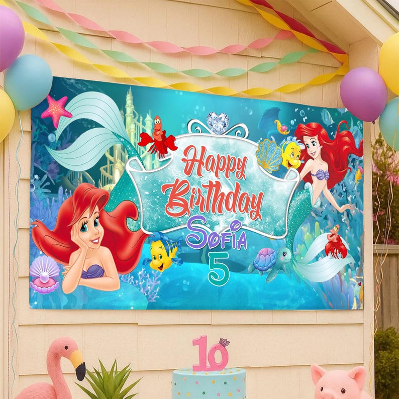 Puede incluir: Una pancarta de cumplea&ntilde;os rectangular que presenta una escena submarina con Ariel, Flounder y Sebasti&aacute;n. El centro muestra el texto Happy Birthday Sofia 5 en letra roja y morada. El fondo muestra corales, un castillo y criaturas marinas.