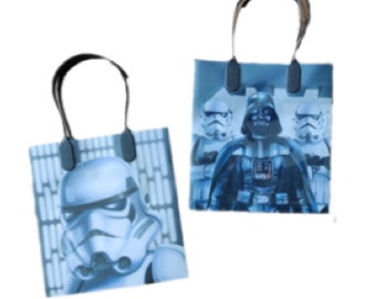 May include: Two Star Wars themed gift bags. One bag features Darth Vader and two Stormtroopers. The other bag features a Stormtrooper. Both bags are blue and white.
