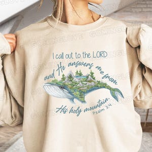 May include: Beige sweatshirt with a blue whale graphic and the text "I call out to the LORD and He answers me from His holy mountain. Psalm 3:4".
