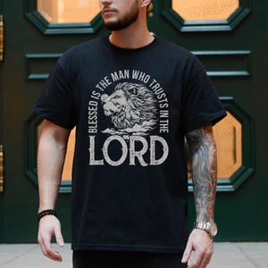 May include: Black t-shirt with a white graphic design featuring a lion's head and the text "Blessed is the man who trusts in the Lord".