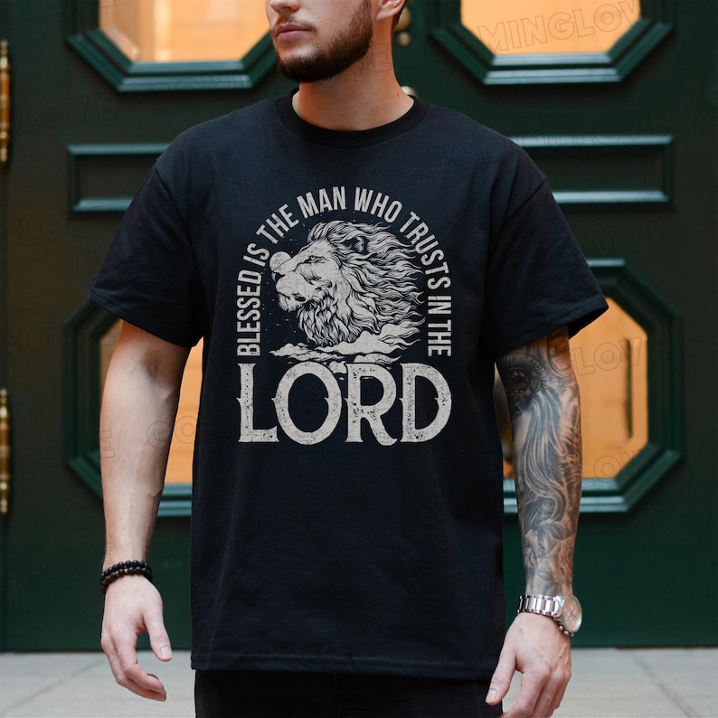May include: Black t-shirt with a white graphic design featuring a lion's head and the text "Blessed is the man who trusts in the Lord".