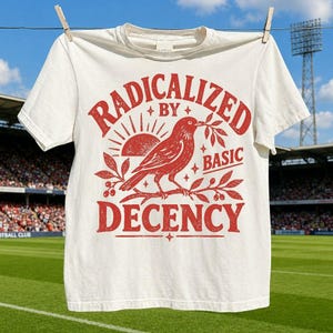 Könnte beinhalten: Ein cremefarbenes Kurzarm-T-Shirt mit einem roten Grafikdruck eines Vogels, der auf einem Ast sitzt, begleitet von einer Sonne und Blättern. Der Text RADICALIZED BY BASIC DECENCY ist in roten Großbuchstaben um die Vogelillustration gedruckt.