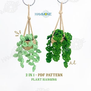 May include: Two crocheted hanging plants with green leaves and brown pots. The plants are hanging from a string with a metal ring at the top. The text "2 IN 1 - PDF PATTERN PLANT HANGING" is below the plants.